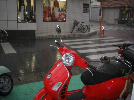 雨宿りする納車直前のGTSと店先の風景