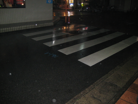 夜の雨の中、K.B.SCOOTERS前の横断歩道
