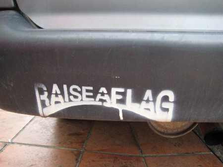 バンパーにスプレーで描かれた「RAISE A FLAG」の文字