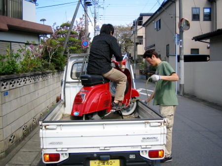 赤いVespa 50sを軽トラに載せ納車する様子