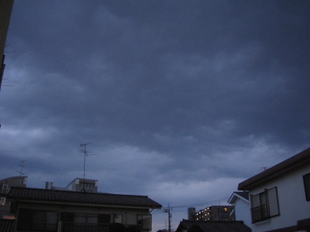 夕暮れ時の重たく流れる雲、色の違いが層になった印象的な空模様