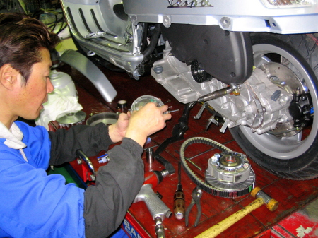 GTS250新車の納車整備中、ウエイトローラーを点検する整備士の手元。