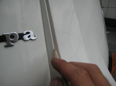 車体の細い凹みに入り込んだWAXを竹の割り箸で掃除している様子。