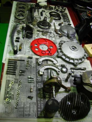 分解されたvespaエンジン部品が整然と並ぶ作業台