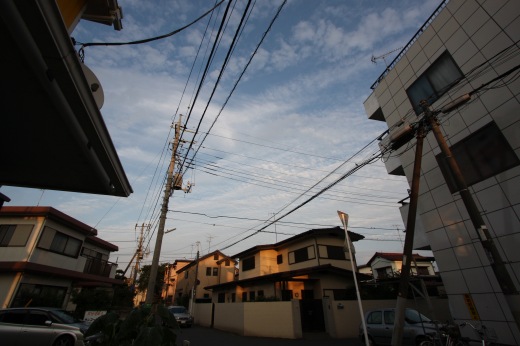 夕暮れ時の住宅街と電線、やわらかな秋の空