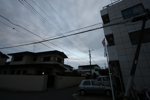 夕方の住宅街に広がる曇り空と電線の風景