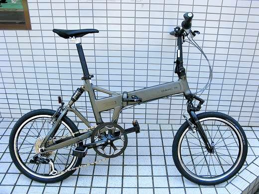 白いタイル壁の前に停められたDAHONの折りたたみ自転車🚲