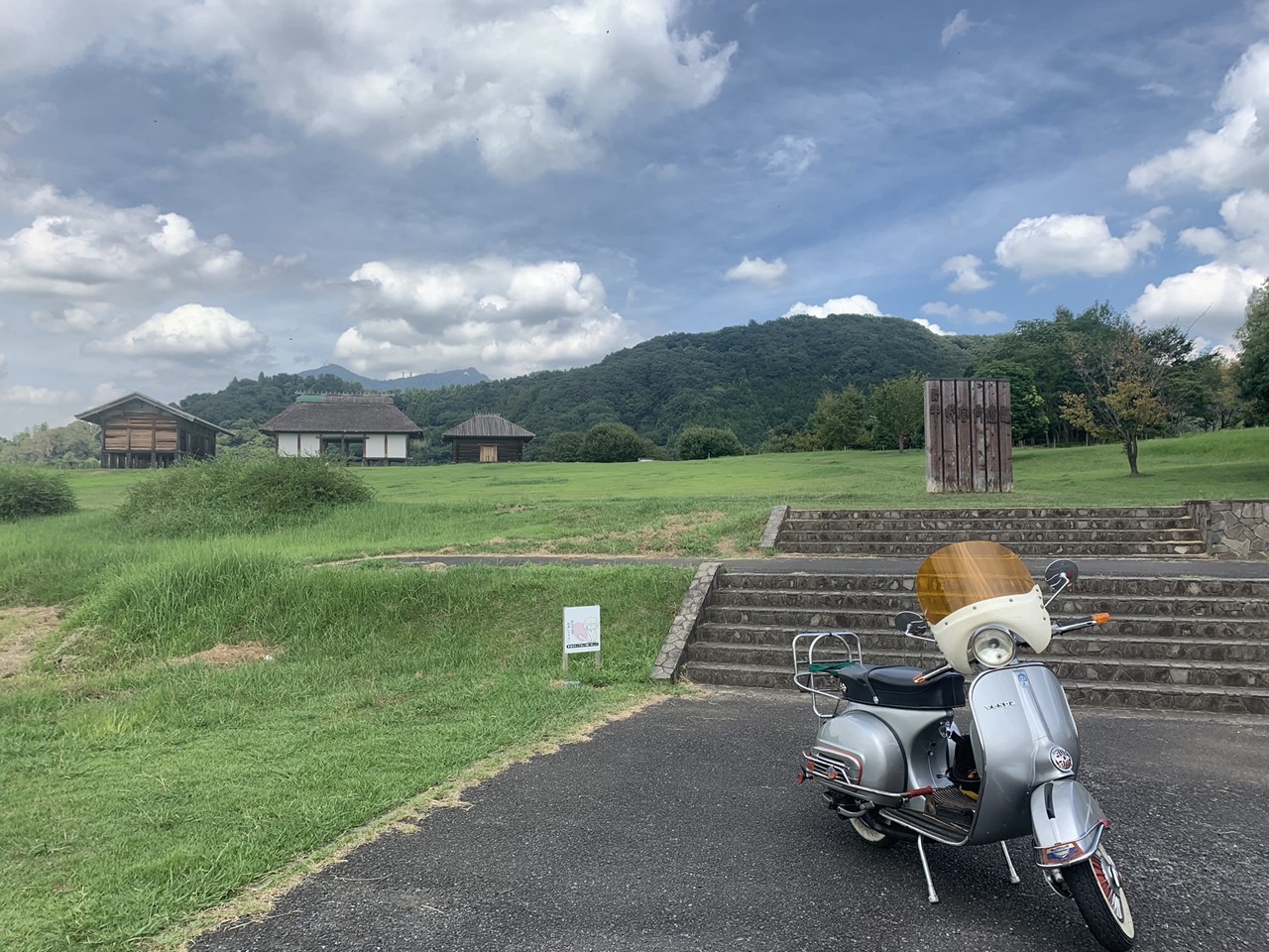 ガレージ前に停められた夜のベスパRALLY200。ライトが反射して輝く。