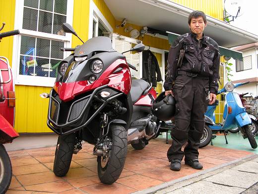 納車された赤と黒の三輪スクーターFUCCOに乗るライダー