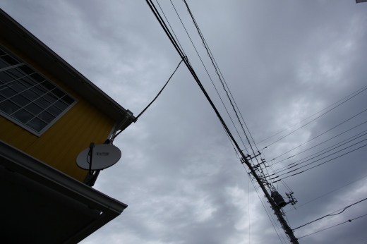 曇り空の下に佇むベスパと黄色い建物