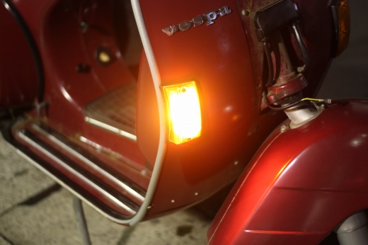 点灯中のフロントウィンカーと赤いP125Xのフロントまわり