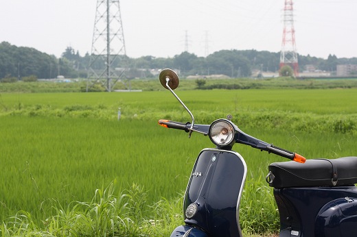 緑の田んぼを背景に手賀沼周辺を走るベスパET3