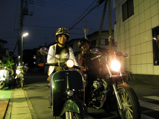 夜の街でベスパとバイクに乗るお客様たち