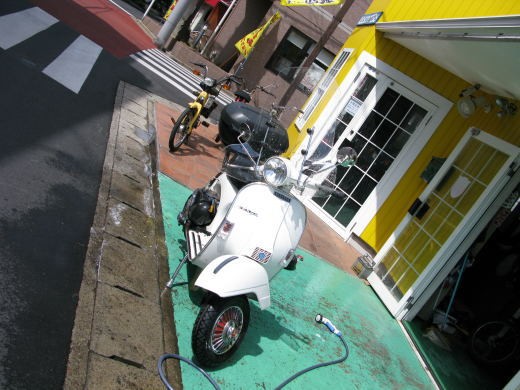 春の日差しの中でベスパを丁寧に洗車している様子