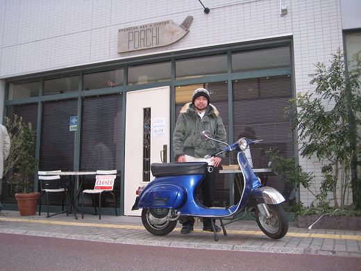 修理が完了したベスパ50Sを前にPORCHI店前で撮影されたシェフの写真