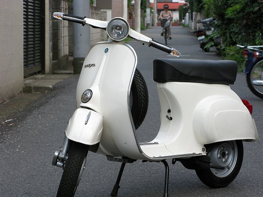 🛵 アイボリーのベスパ50sが路地に停車している様子