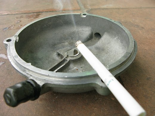 🚬 灰皿として使われたクラッチカバーにタバコが置かれている写真