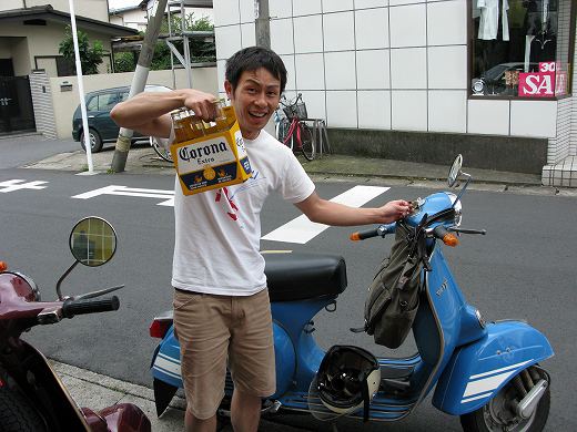 CORONAビールの差し入れを持つベスパ乗りのお客様