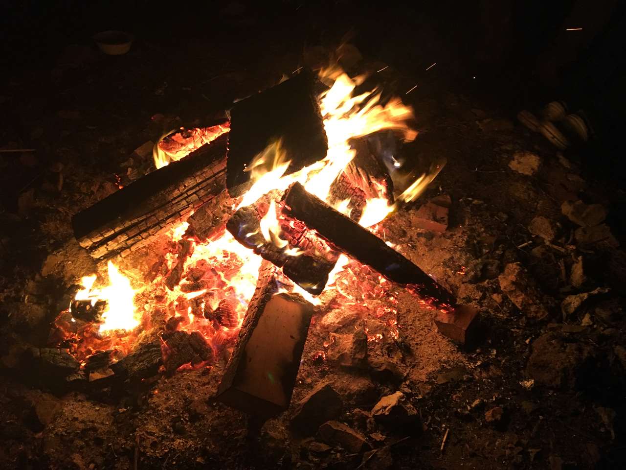 夜の焚き火、薪が赤く燃える様子