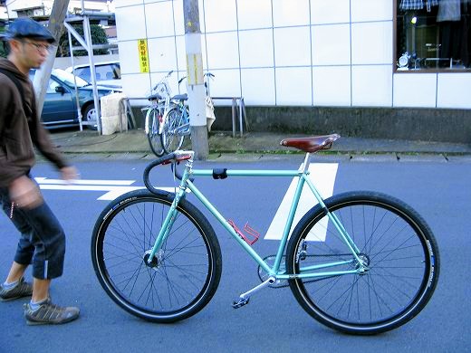 店舗前でシングルスピードの自転車に乗る来店客