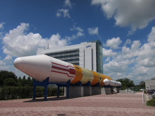 JAXA筑波宇宙センターに展示された大型ロケットとビル