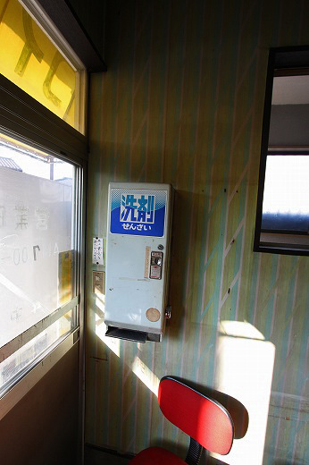 コインランドリーの洗剤自販機と赤い椅子