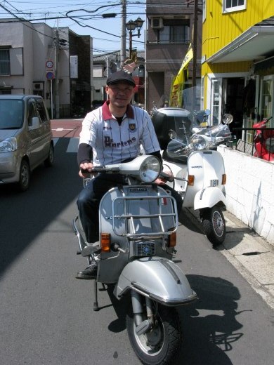 PX200Eに跨ったスキンヘッドの男性、満面の笑みで記念撮影