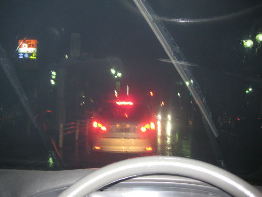 車内から見た雨の夜道とブレーキランプの風景