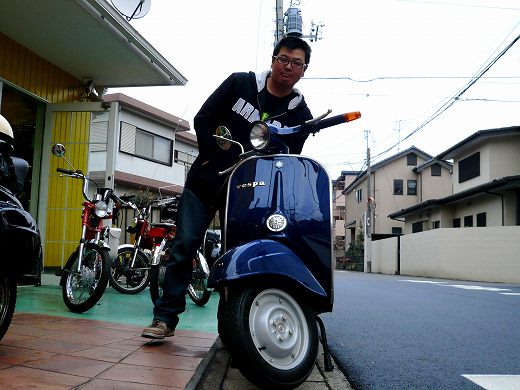 青いベスパと納車記念撮影をするお客様の笑顔