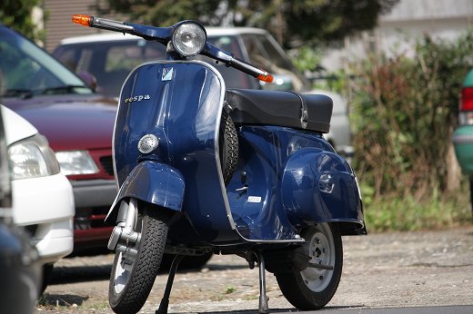 青空の下で撮影されたVespa 50sの横顔ショット