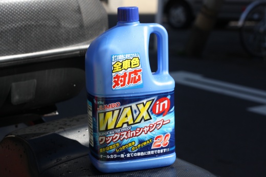 青いボトルのワックスインカーシャンプーがベスパのシート上に置かれている様子