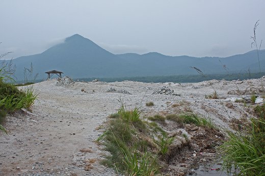 白い砂地が広がる荒涼とした風景。遠くに山が霞み、静けさと寂しさが漂う