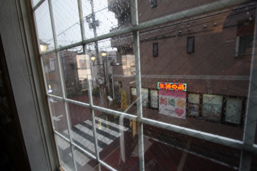 窓越しに見える雨の街並み
