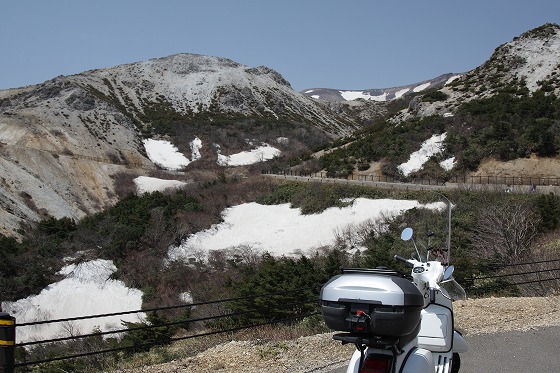 磐梯吾妻スカイラインを白いベスパで走行中に見た残雪と山肌の景色