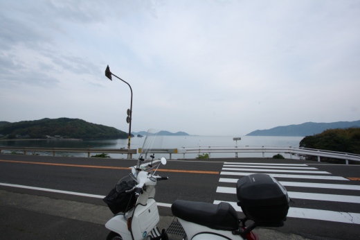 日本海を背景に停車している白いベスパ