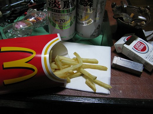 冷えたマックのポテトと缶ビール、タバコが並ぶ晩酌の様子