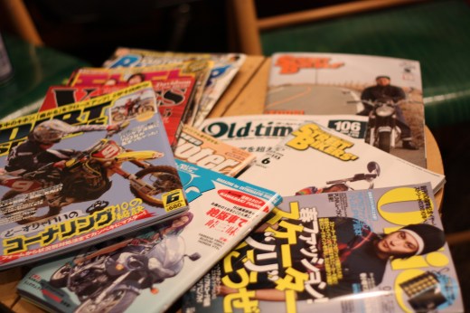 テーブルに広げられた様々なバイク雑誌の束