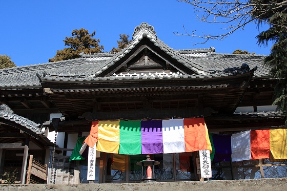 石段を登って参拝する人と「謹賀新年」の扁額が掲げられたお堂