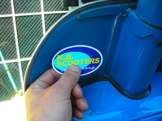 K.B.SCOOTERSのステッカーをP125Xに貼り付けている場面