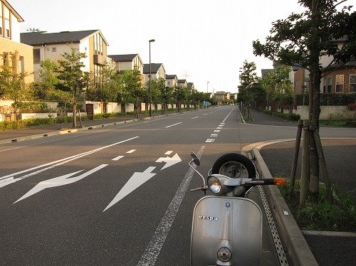 川沿いの道で青いベスパを止めて撮影した様子