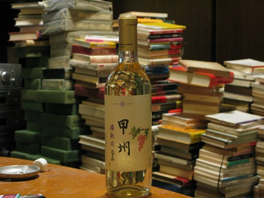 🍷 本棚の前に置かれた白ワインのボトル