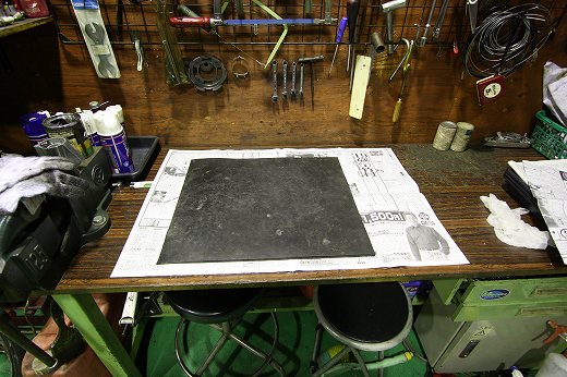 作業台に敷かれたゴムマットと新聞紙