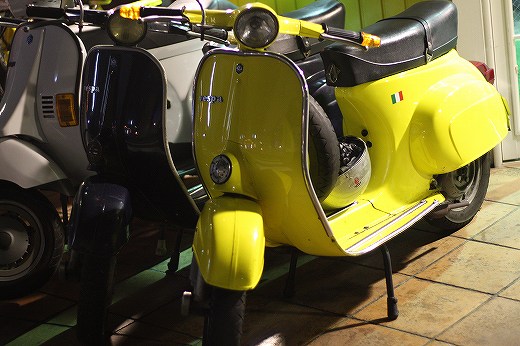 店舗内に並ぶ黄色いベスパと他の車両たち