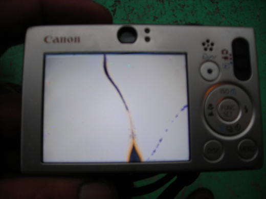 液晶画面が割れたまま表示が崩れたデジカメの裏面写真