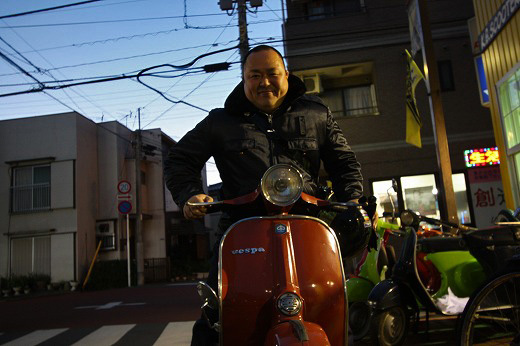 夕暮れの店先で笑顔のお客様とVespa Rally200