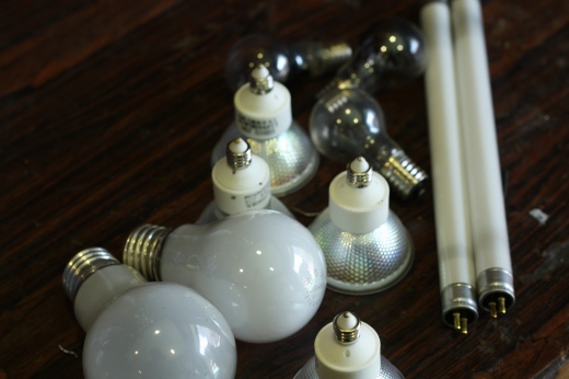 使用済みの電球や蛍光灯が無造作に並べられた状態