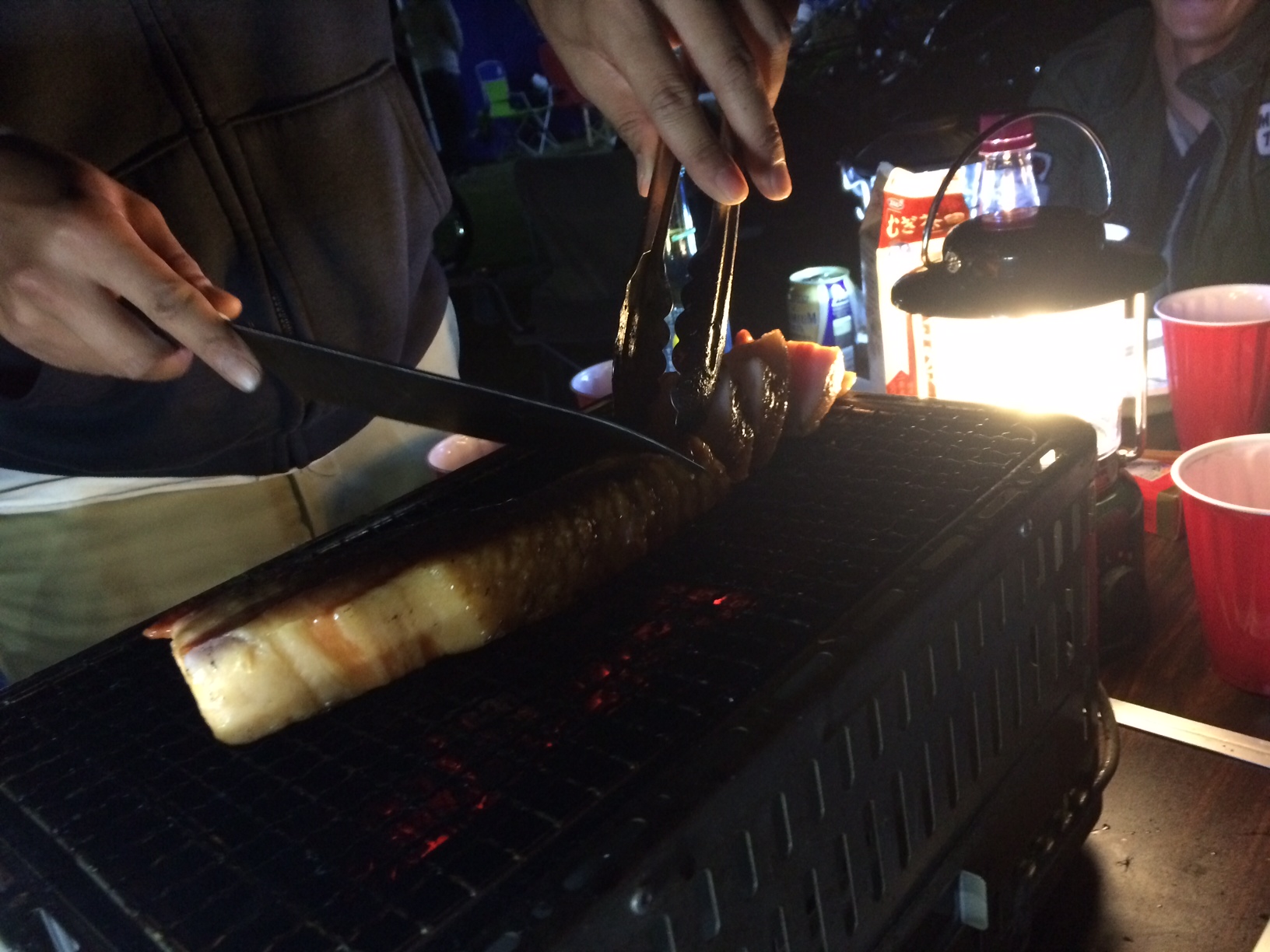 網の上で分厚い肉を焼くキャンプでの一場面