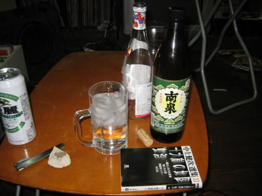 芋焼酎と文庫本が置かれたテーブルの晩酌風景