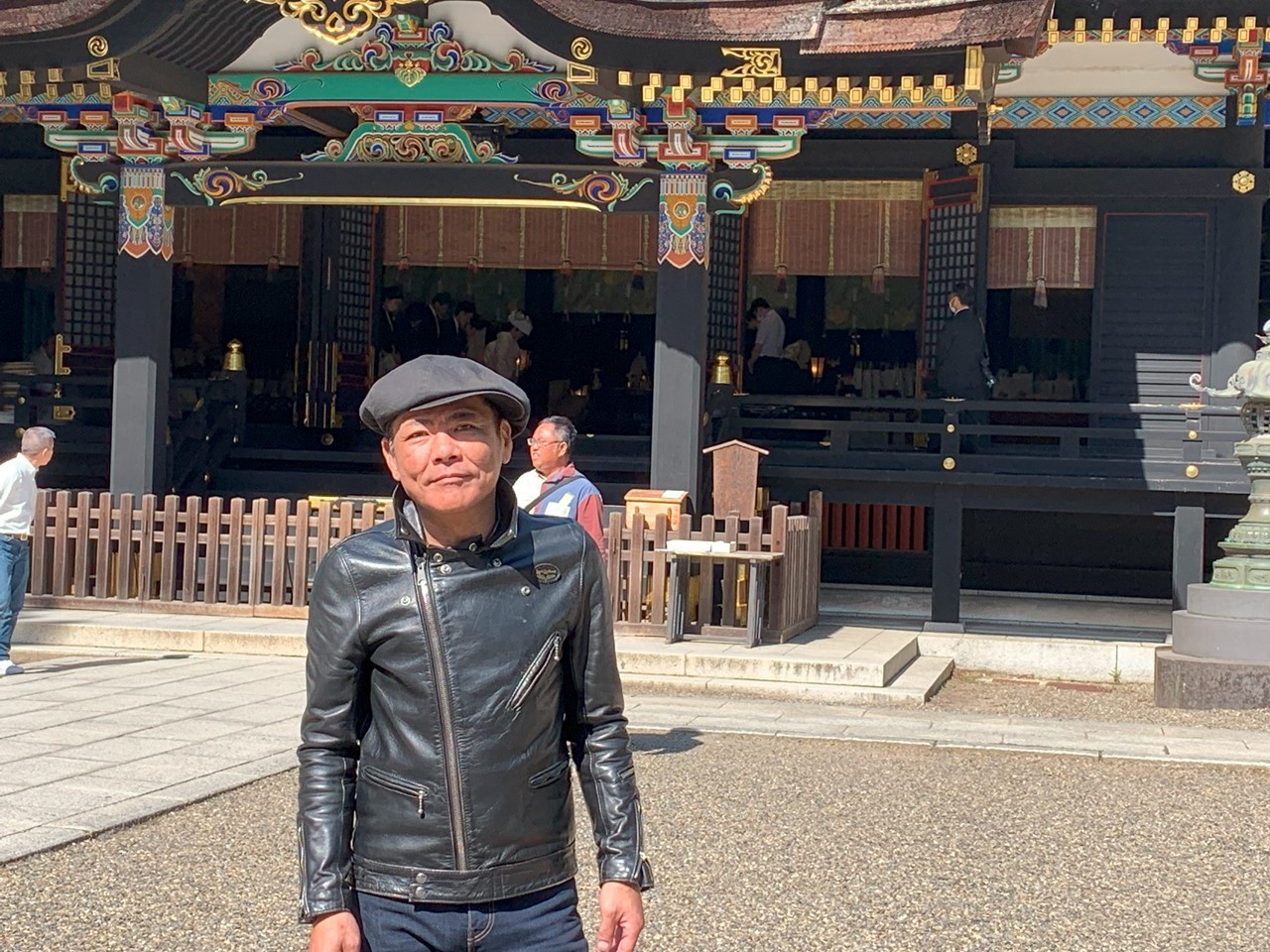 香取神宮の拝殿前で撮影された人物。漆塗りの社殿と鮮やかな装飾が印象的。