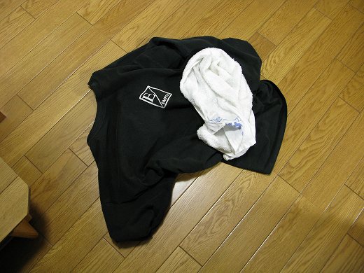 仕事後に脱いだTシャツとタオルが床に置かれた様子